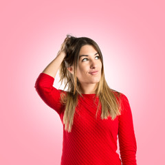 Young girl thinking over isolated pink background