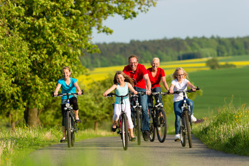 Fototapeta Familie fährt Fahrrad im Sommer obraz