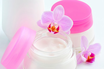 Obraz na płótnie Canvas Face creams and beautiful orchid flowers on white background
