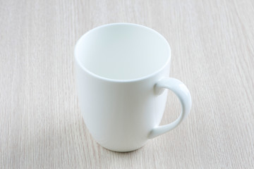 White cup on wood table