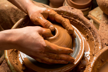 hands of a potter, creating an earthen jar