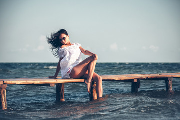 Young woman in a white dress on the beach