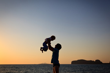 father and son silhouettes at the beach