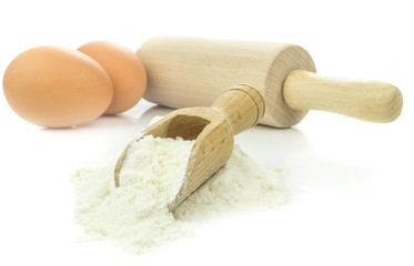 Flour and eggs with baking utensils on white background