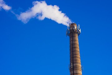 Smoking brick tower with mobile antenna on top