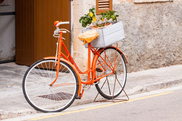Fototapeta na wymiar damen fahrrad in orange mit blumen im korb