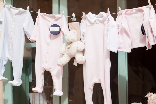 kleine baby strampler auf der w&auml;scheleine im schaufenster