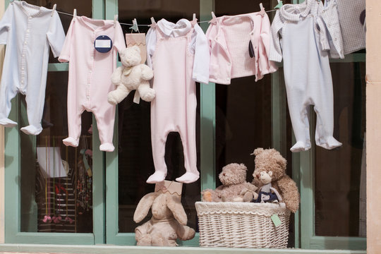 kleine baby strampler auf der w&auml;scheleine im schaufenster