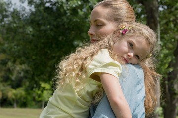 Obraz premium Mother carrying daughter at park