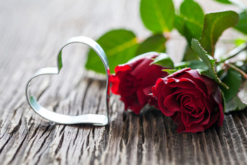 Rosen und Herzform auf Holzuntergrund