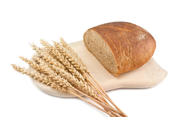 a loaf of bread and ears of corn on a cutting board