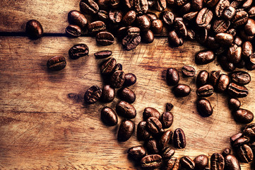Coffee on grunge wooden background closeup. Roasted  coffee bean