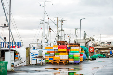 fischerboot angedockt am kai im hafen mit kontainern