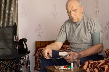 Senior handicapped man taking his blood pressure