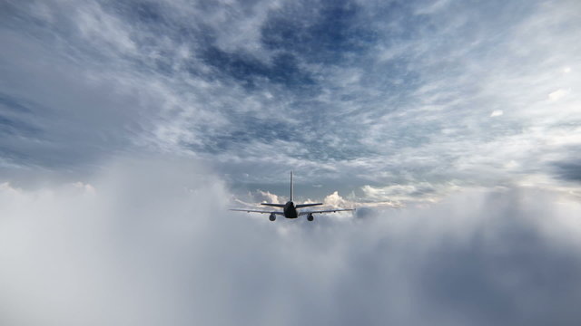 Airplane seen from behind flying above the clouds