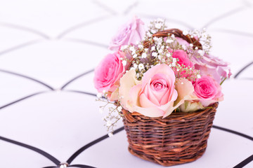pink roses in brown basket of withe background