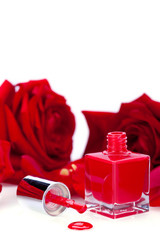 eleganter roter nagellack in glasflasche mit roten rosen