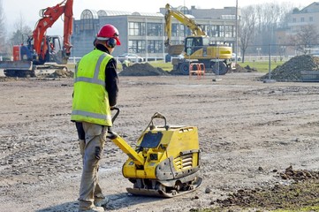 ouvrier utilisant une plaque vibrante