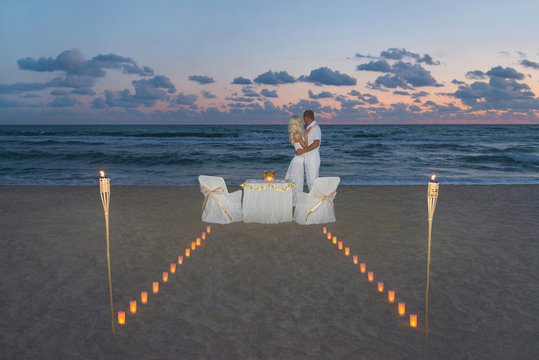Couple at sea beach during luxury romantic dinner, decorated wit