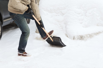 closeup of man shoveling snow from driveway