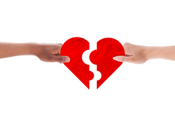 Mixed couple hands holding holding heart shape puzzle
