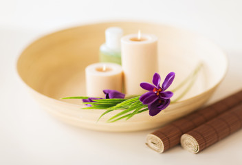 Fototapeta na wymiar świece i kwiaty irysa w drewnianym jelit i maty