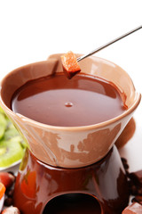 Chocolate fondue with fruits, isolated on white