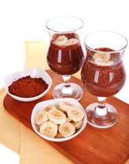 Cocktails with banana and chocolate on table on white