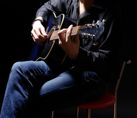 Fototapeta na wymiar Młody muzyk grający na gitarze akustycznej i śpiewu,