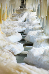 Winter. Baltic Sea. Ice formations icicles on pier poles