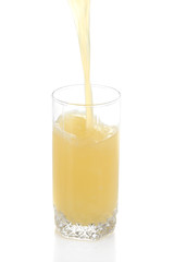 Juice pouring into glass isolated on white