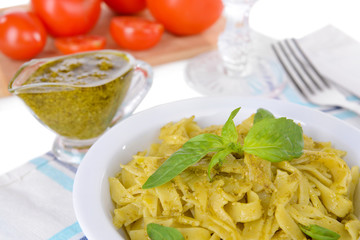 Delicious pasta with pesto on plate on table close-up