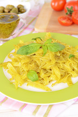 Delicious pasta with pesto on plate on table close-up