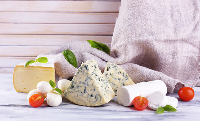 Different tasty cheese, on wooden table