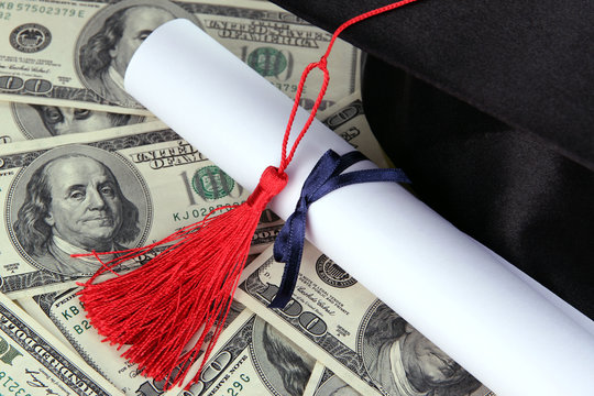 Graduation Hat And Scroll On Money Background