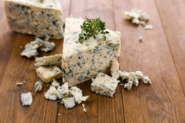 Tasty blue cheese with thyme, on wooden table