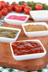 Various sauces on chopping board on table close-up