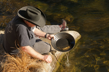 Man beside river gold panning