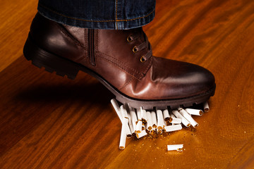 shoes trampling down on cigarettes