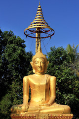 Obraz premium Buddha statue under golden umbrella