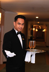 waiter or butler in uniform at five star hotel corridor