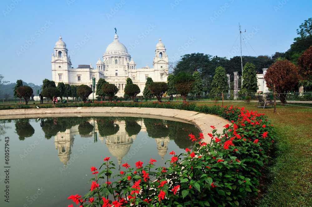 Wall mural Victoria Memorial, Kolkata , Calcutta, West Bengal, India with blue sky and reflection on water. A Historical Monument of Indian architecture, to commemorate Queen Victoria's 25 years reign in India.