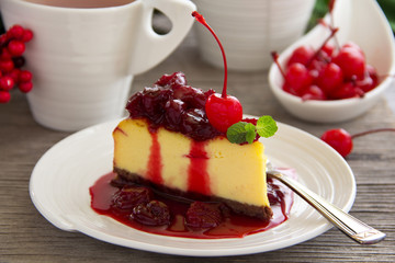 A slice of cheesecake with cherry sauce.