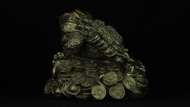 Money toad rotates on a black background loop