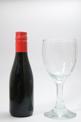 Red wine bottle and clear glass.