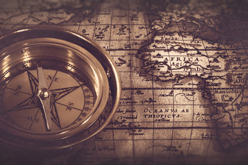 Old nautical compass over the map, abstract retro still life