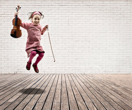 little girl with violin jumping