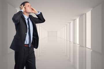 Composite image of stressed businessman with hands on head