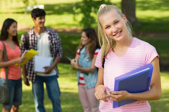 Girl with college friends in background at campus