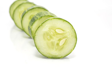 Stack of green cucumber slices with reflection isolated on white